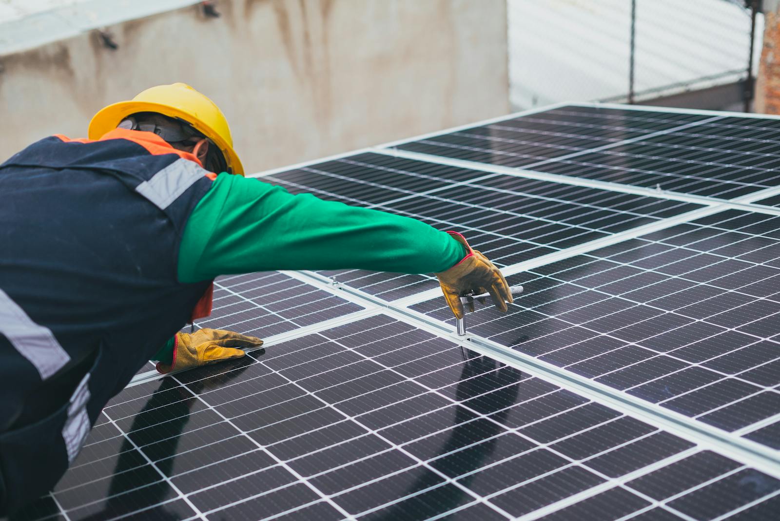Solar technician installing panels on rooftop